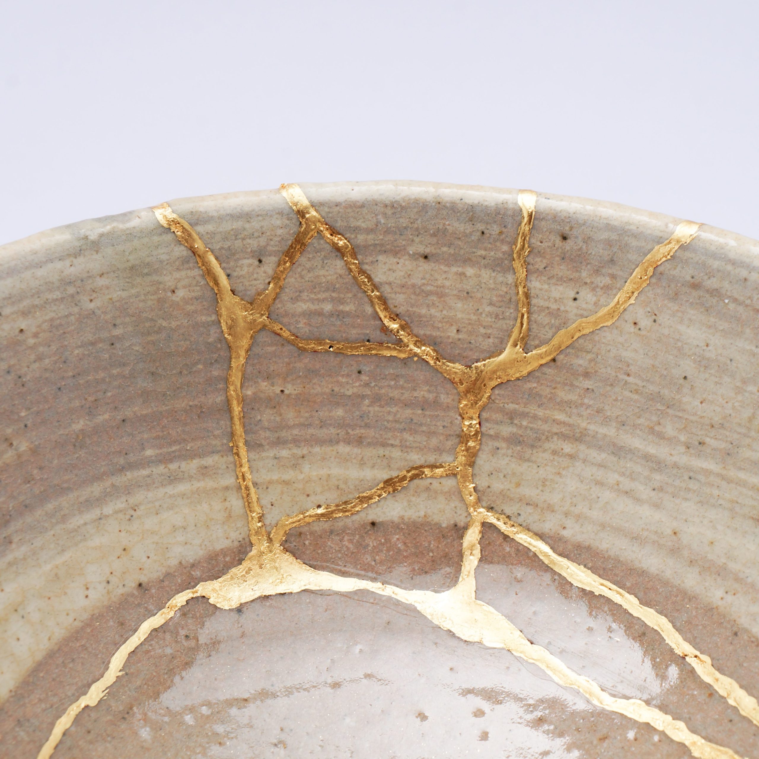 antique broken japanese beige bowl repaired with gold kintsugi technique